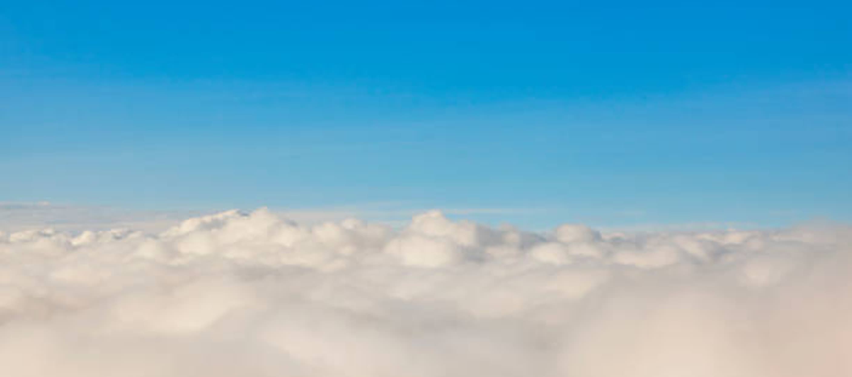 an image of the blue sky with a bird's eye view of somewhat gray cloud underneath